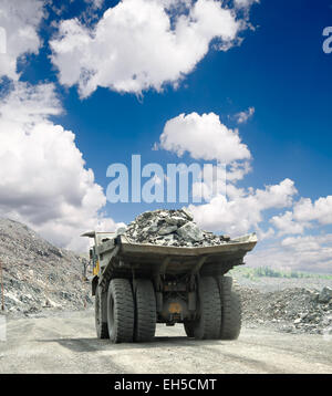 Heavy dump truck carrying the iron ore on the opencast mining Stock Photo