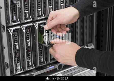 It engineer / technician working in a data center. Replace a local hard drive in a blade serevr. Stock Photo