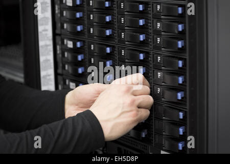 It engineer / technician working in a data center. Replace a hard drive in a SAN. Stock Photo