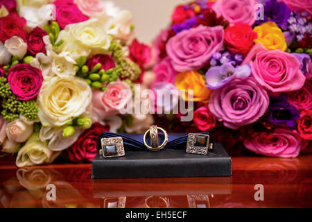 Bride and groom rings, cufflinks, bride's bouquet and a wedding godmother Stock Photo
