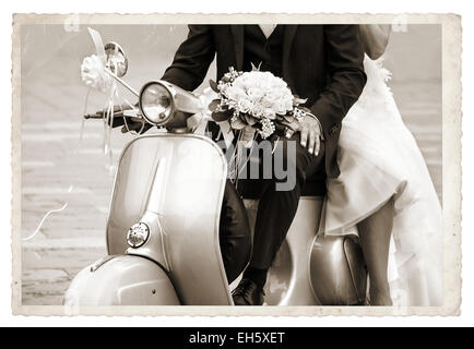 Vintage photo with Young newlywed just married, posing on an old gray scooter Stock Photo