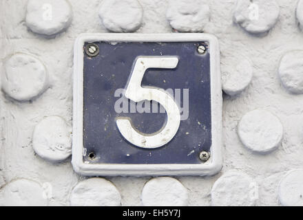 Number five on the wall of a house, detail of a number of information, odd number Stock Photo