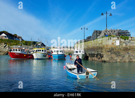 Man in dinghy, Newquay Harbour, Cornwall, England UK Stock Photo