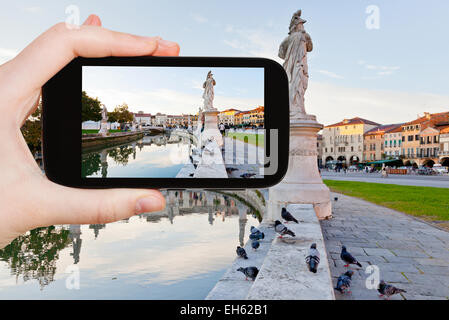 travel concept - tourist taking photo of Prato della Valle in Padua, Italy on mobile gadget Stock Photo