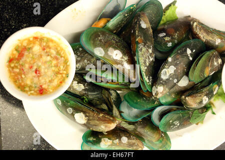 Boiled mussels on white dish in a restaurant.