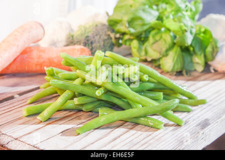 A pile of green beans, in front of other vegetables Stock Photo