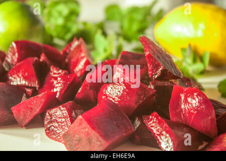 Lilac beetroot diced on a white table, near lemon and mint Stock Photo
