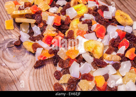 A Pile of dried papaya, raisins, pineapple, banana and cocos fruits. On a wooden table Stock Photo