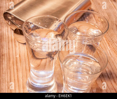 https://l450v.alamy.com/450v/eh6ek1/three-glasses-full-of-vodka-near-a-pocket-flask-eh6ek1.jpg