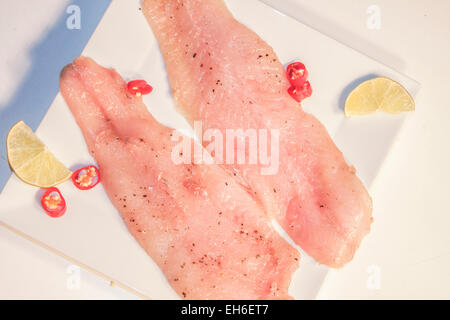 Raw pike perch, chili and lime. On a white plate Stock Photo