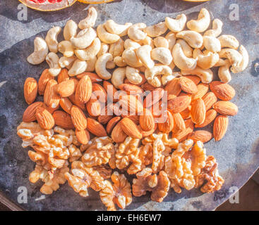 Cashew nuts, almonds and walnuts, on a stone plate Stock Photo
