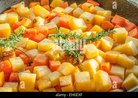 Green thyme on diced carrots and swedes Stock Photo