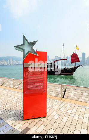 A junk sailing past the Avenue of Stars, Tsim Sha Tsui, Kowloon, Hong Kong Stock Photo