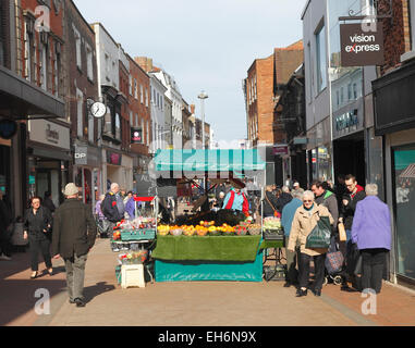 High street shopping in King's Lynn, Norfolk with a fruit and veg market stall. Stock Photo