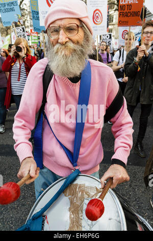 London, UK. 7th March, 2015  'Participant in the Time for Action'  demonstration beats a drum along the route of the march. Stock Photo