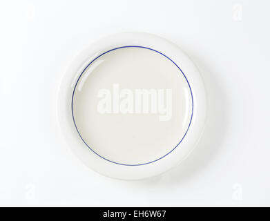White shallow dinner plate with blue ring Stock Photo