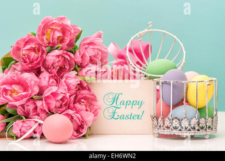 Tulip flowers and pastel colored easter eggs. Festive decoration with greetings card and sample text Happy Easter! Stock Photo
