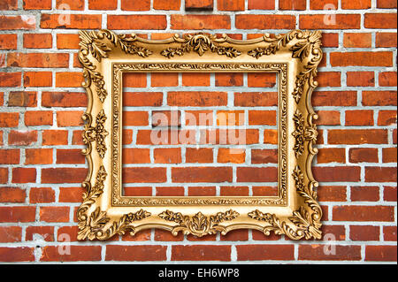Baroque golden frame on red brick wall. Stone texture background Stock Photo