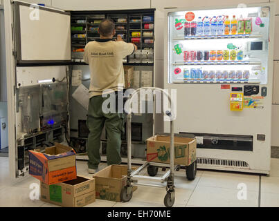 serviceman supplies drinks to vending machine Stock Photo