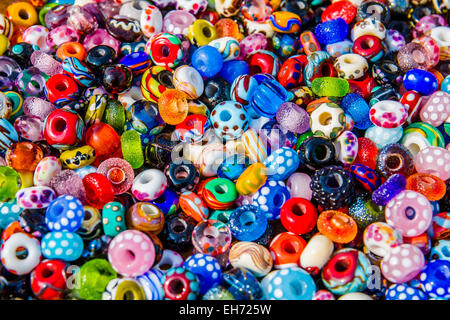 Glass and clay beads of different shapes and colors displayed in bulk at local fair Stock Photo