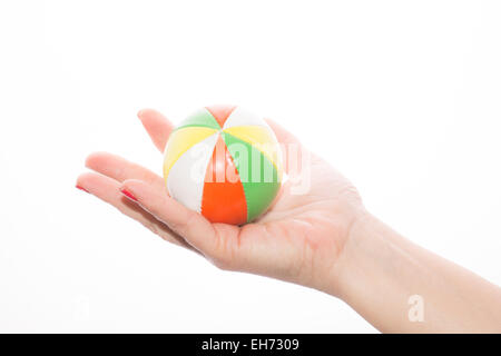 female hand holding colored juggling balls on a white background Stock Photo