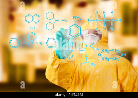 Laboratory man in chemical protective dress drawing chemical formula on foreground Stock Photo
