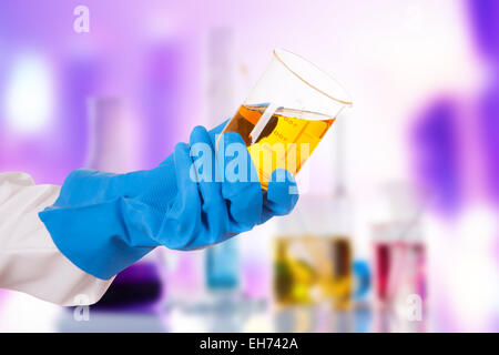 Hand holding chemical liquid in glass flask in laboratory Stock Photo