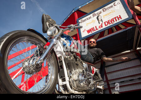 Daytona Beach, FL, USA. 8th Mar, 2015. A motorcycle stunt performer rests on his Harley-Davidson bike in front of the Wall of Death sideshow during the 74th Annual Daytona Bike Week March 8, 2015 in Daytona Beach, Florida. Credit:  Richard Ellis/ZUMA Wire/Alamy Live News Stock Photo
