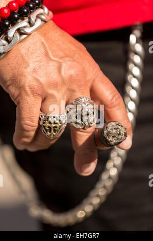 A biker wearing rings and holding a cigar during the 74th Annual Daytona Bike Week March 8, 2015 in Daytona Beach, Florida. More than 500,000 bikers and spectators gather for the week long event, the largest motorcycle rally in America. Stock Photo