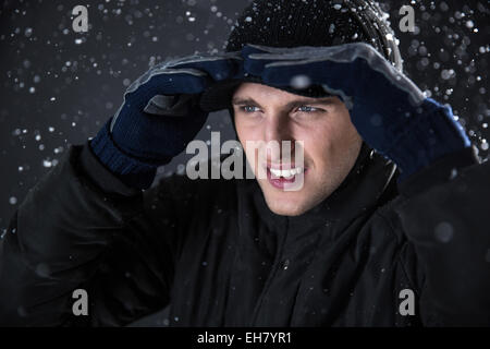 Handsome man looking away with snow on background Stock Photo