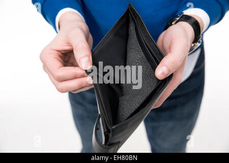 Closeup image of a man holding emty wallet over white background Stock Photo