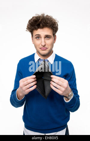 Upset young man holding emty wallet over white background Stock Photo