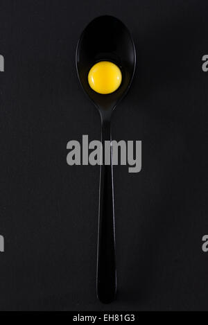 Quail eggs in spoon on black background Stock Photo