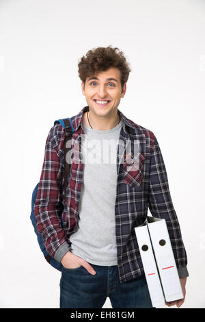 Happy young man standing with backpack and folders Stock Photo