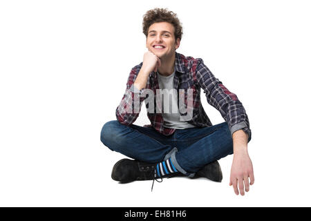Smiling young man sitting on the floor over white background Stock Photo