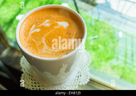 Matcha green tea in white cup with milk froth drawing on top Stock Photo