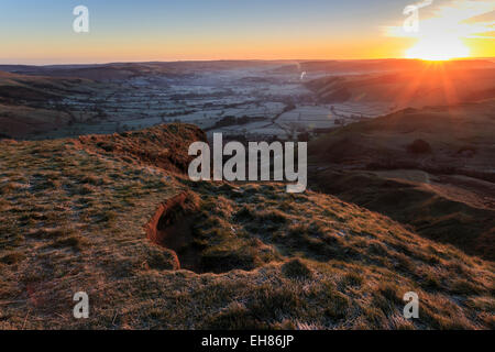 Mam Tor (Shivering Mountain), exposed east face strata lit by rising sun in winter, Castleton, Derbyshire, England, UK Stock Photo