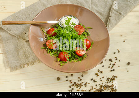 Watercress salad with cherry tomatoes and sour cream. Overhead view. From series Natural organic food Stock Photo