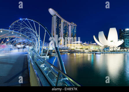 Singapore - July 10: Blurred people walking on the Helix Bridge leading to Marina Bay Sands Hotel, 10 July 2013. Stock Photo