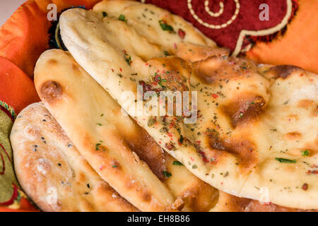 The traditional way to bake Naan, an Indian yeasted flat bread, is in a clay or earthen oven. Stock Photo