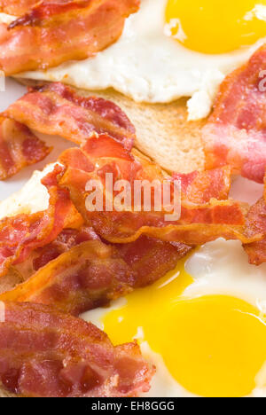 Fried bacon and eggs on white bread. Stock Photo
