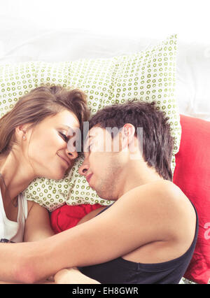 Happy young romantic mixed couple in bed Stock Photo