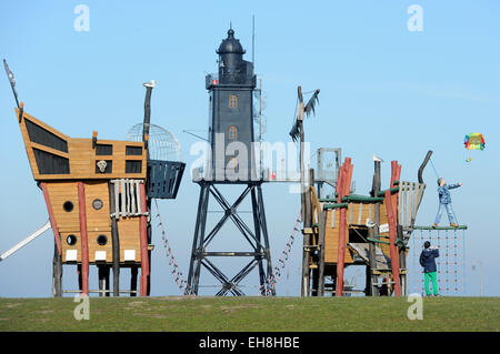 Dorum, Germany. 08th Mar, 2015. Children let their parachute fly in the wind on the 'stranded pirate ship' in front of the museum lighthouse Obereversand at the Siel harbor entrance of Dorum, Germany, 08 March 2015. Early spring is coming to the German North Sea coast with sunshine and temperatures around twelve degrees Celsius. Photo: Ingo Wagner/dpa/Alamy Live News Stock Photo