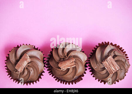 Chocolate cupcakes over a pink backdrop Stock Photo