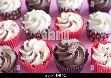 Cream cupcakes over a pink backdrop Stock Photo