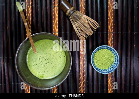 Bowl of Matcha with a Chasen a Chashaku and a bowl of Matcha powder on a place mat Stock Photo