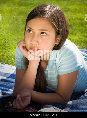 young person people Vietnamese/Caucasian girl 11-13 year old laying on stomach on grass meditating front view Tween tweens  MR  © Myrleen Pearson Stock Photo