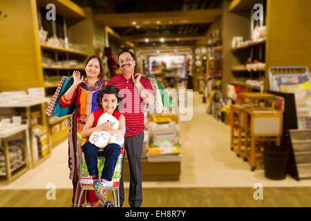 3 indian grand Parents and kid Grand daughter mall Trolley Shopping Stock Photo