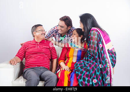 4 indian Adults Parents son and Daughter-In-Law sitting sofa Stock Photo