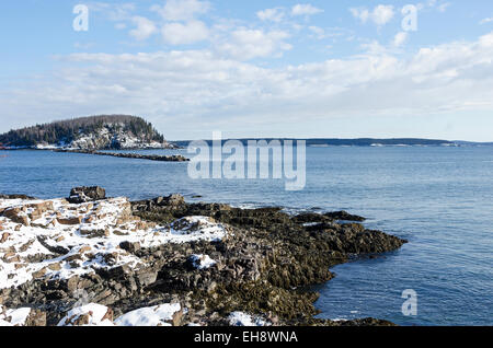 Looking out to Bald Porcupine Island from snow-covered Ogden Point in Bar Harbor, Maine. Stock Photo